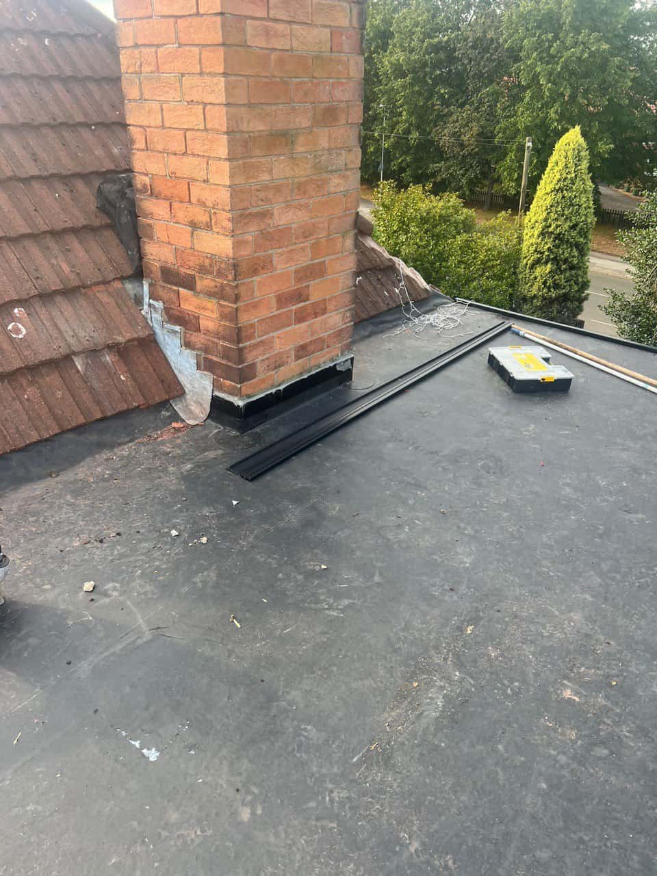 This is a photo of a flat roof which has just been repaired, there is also a chimney stack and some leadwork has also been dressed. Works carried out by Chichester Roofing Repairs